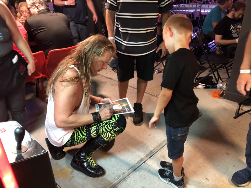 Vinny Lee Glamrock signing an autograph for young fan.